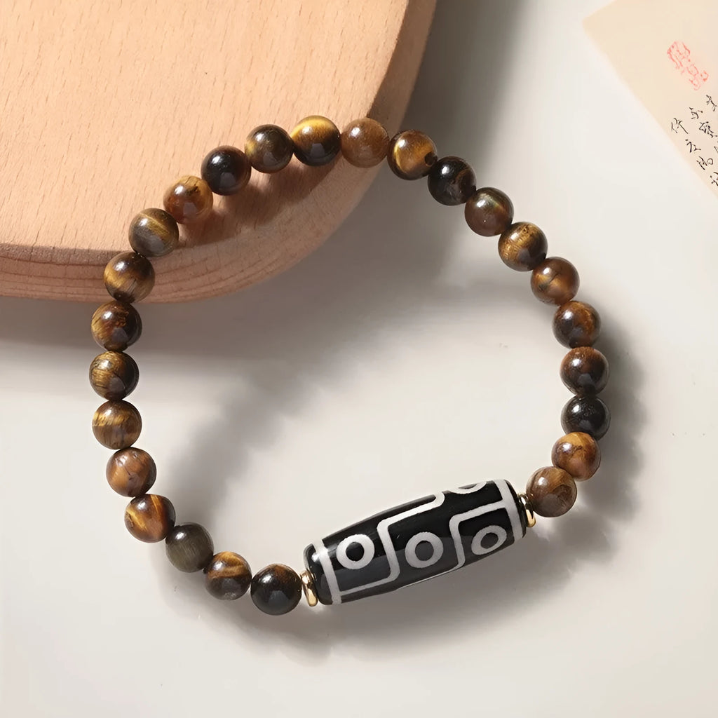 Tigereye Dzi bead single circle Buddha rosary bracelet on a wrist.