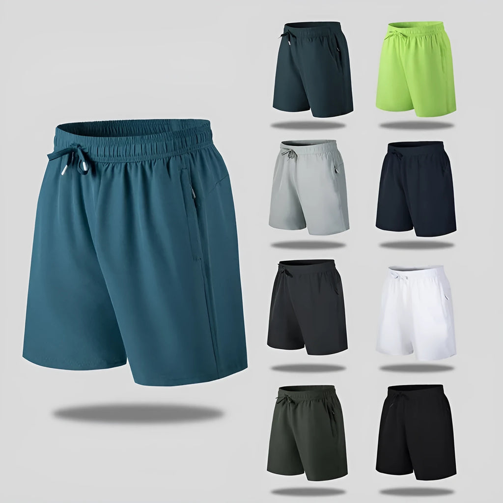 Man wearing loose fit black quick-dry sports shorts on a beach.