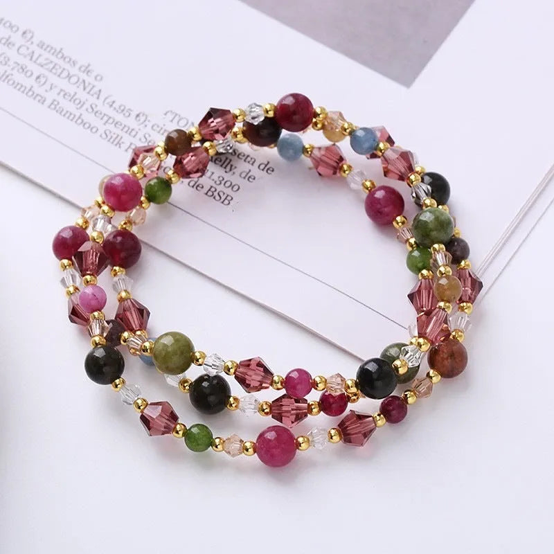 Adjustable bracelet with tourmaline, strawberry quartz, and amethyst crystals in a three-ring design.