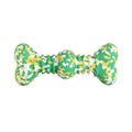 Green and white camouflage pattern natural rubber bone chew toy for large dogs on a wooden floor.