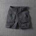 Men's army green cotton cargo shorts with multiple pockets on a straight leg.