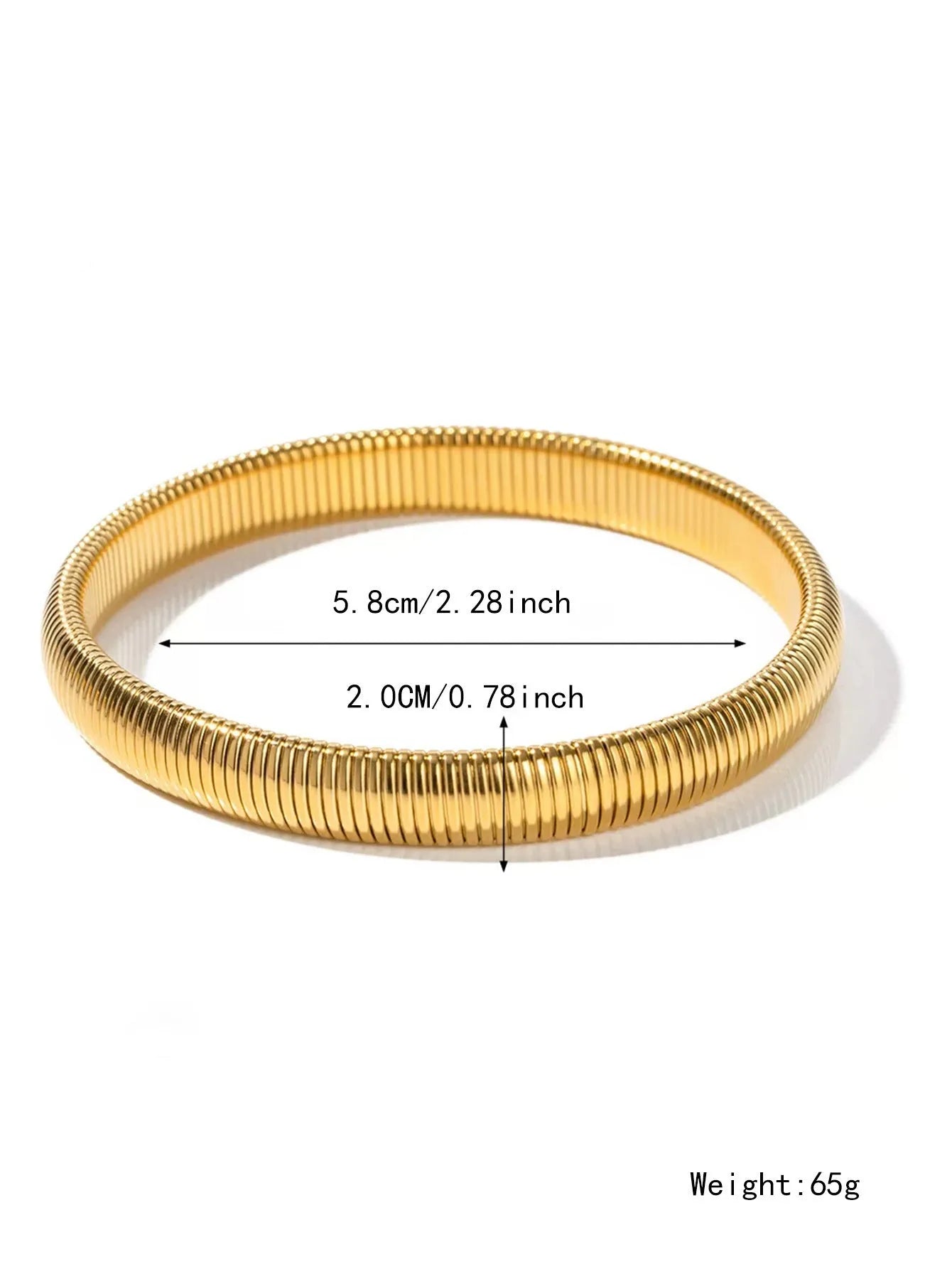 Close-up of a women's titanium steel bracelet with a vertical stripe ring pattern, shown in a gold tone finish on a wrist.