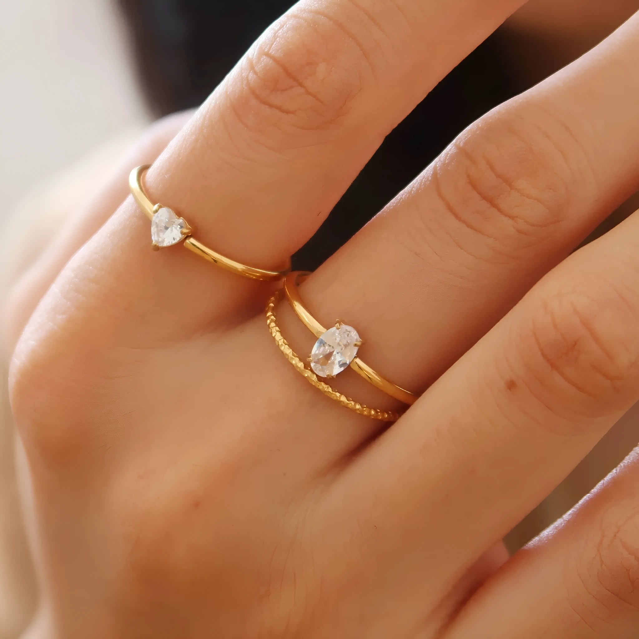Golden heart-shaped stainless steel ring with love oval design on female hand