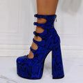 Women's black patent leather platform high heels with a thick heel and buckle-fastened serpentine belt.
