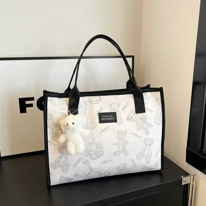 Women's soft canvas tote bag in black, showing large capacity, sandwich pockets, and a rhombus pattern detail.