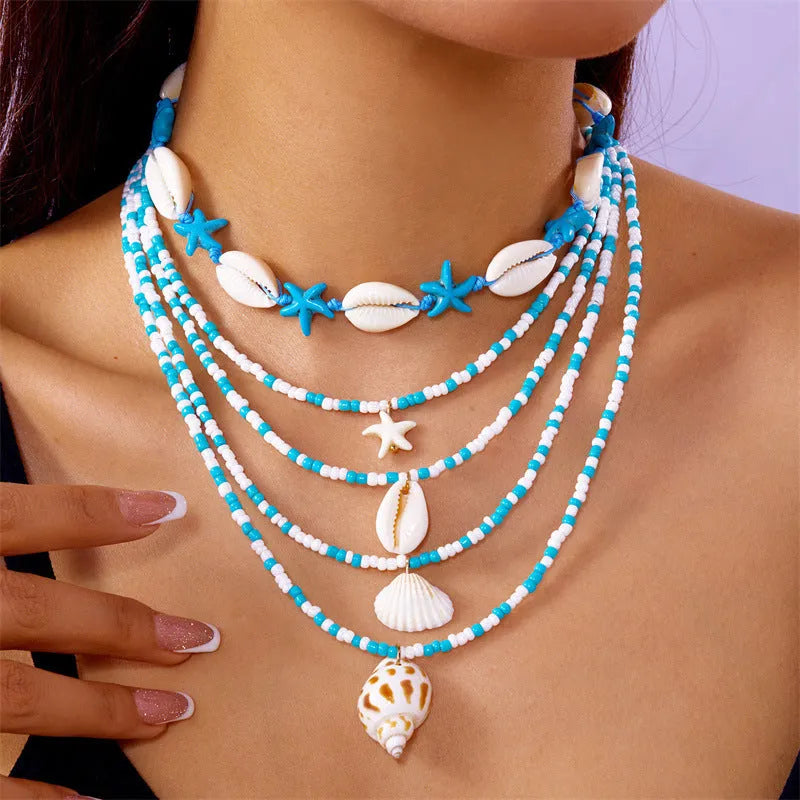 Five-piece women's necklace set with starfish, shell and conch bead pendants on adjustable chains