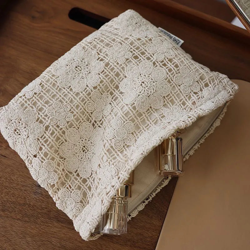Handmade crocheted corduroy cosmetic bag with hollow flower cutouts and ethnic embroidery in a rope colour.