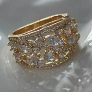 Women's hollow round fashion ring in gold or platinum with a choice of white or blue gemstone.
