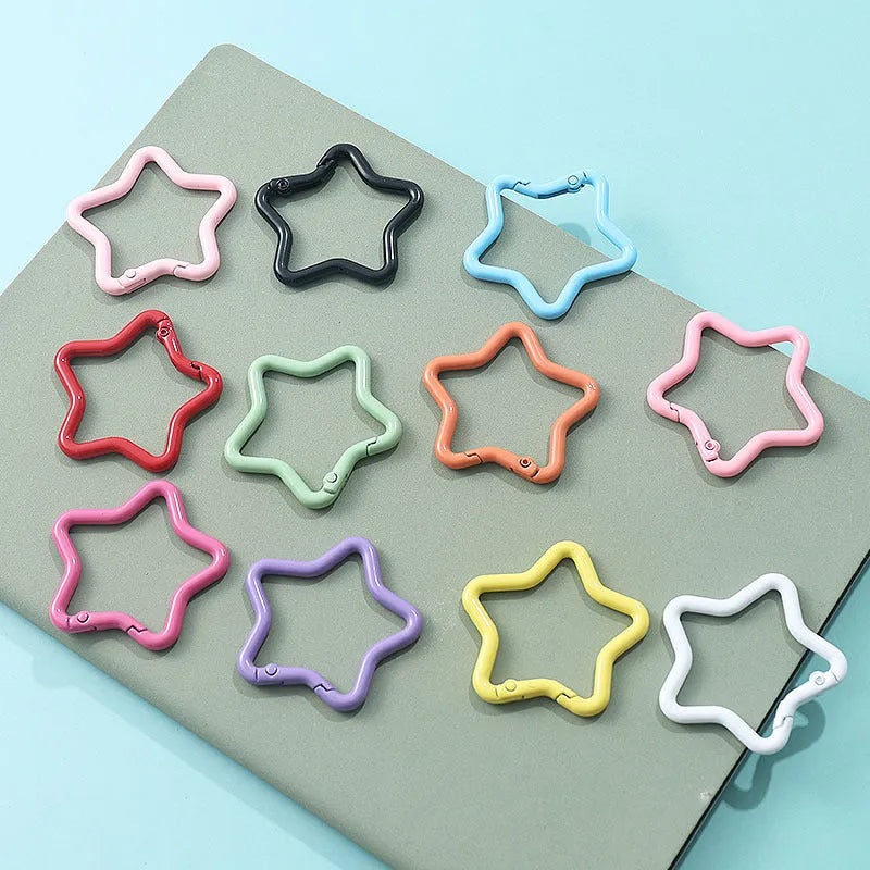 Zinc alloy five-pointed star keychain in light pink colour on a white background.