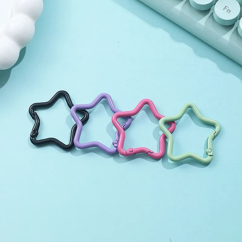 Zinc alloy five-pointed star keychain in light pink colour on a white background.