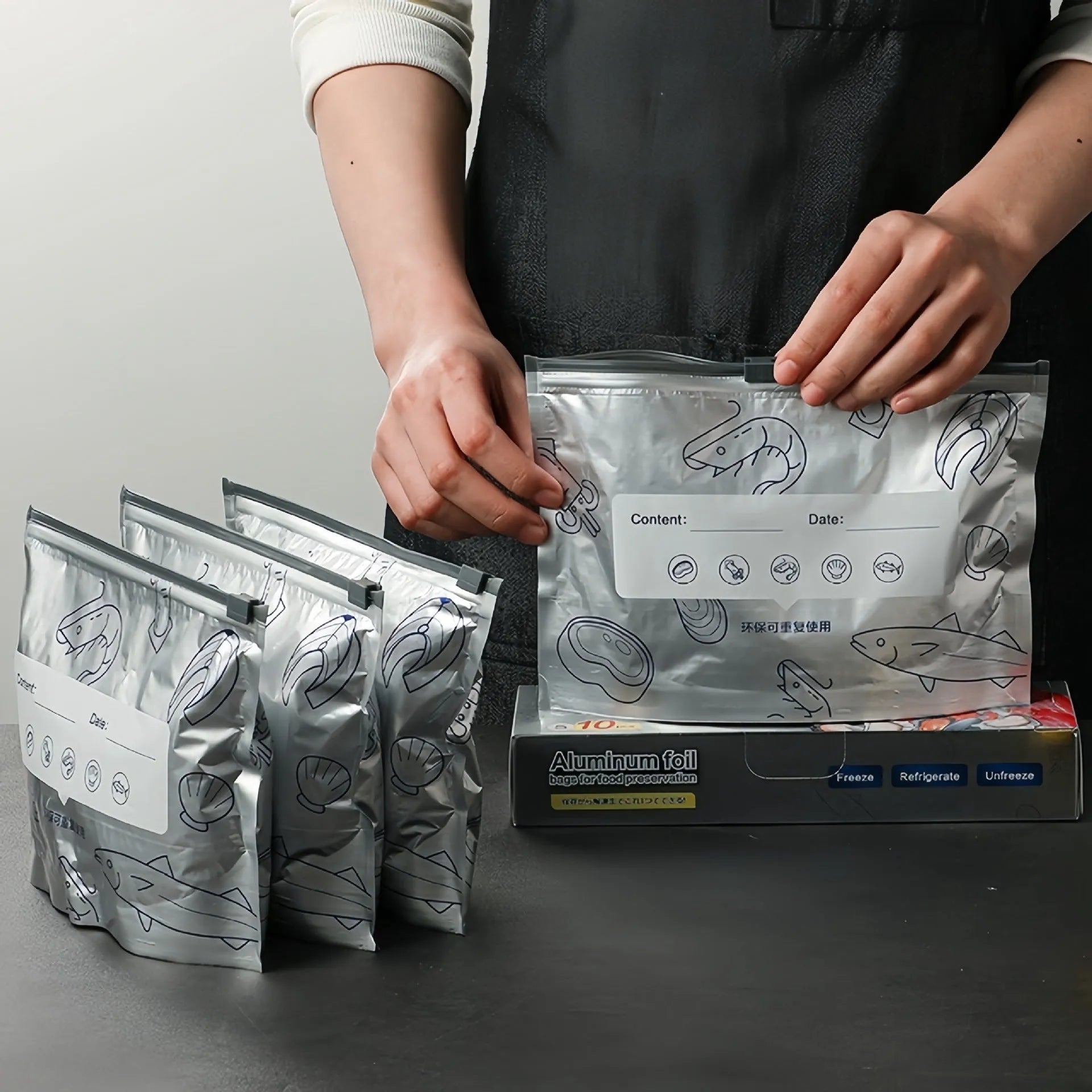 Set of aluminium foil sealed bags and boxes for food preservation in three different sizes.