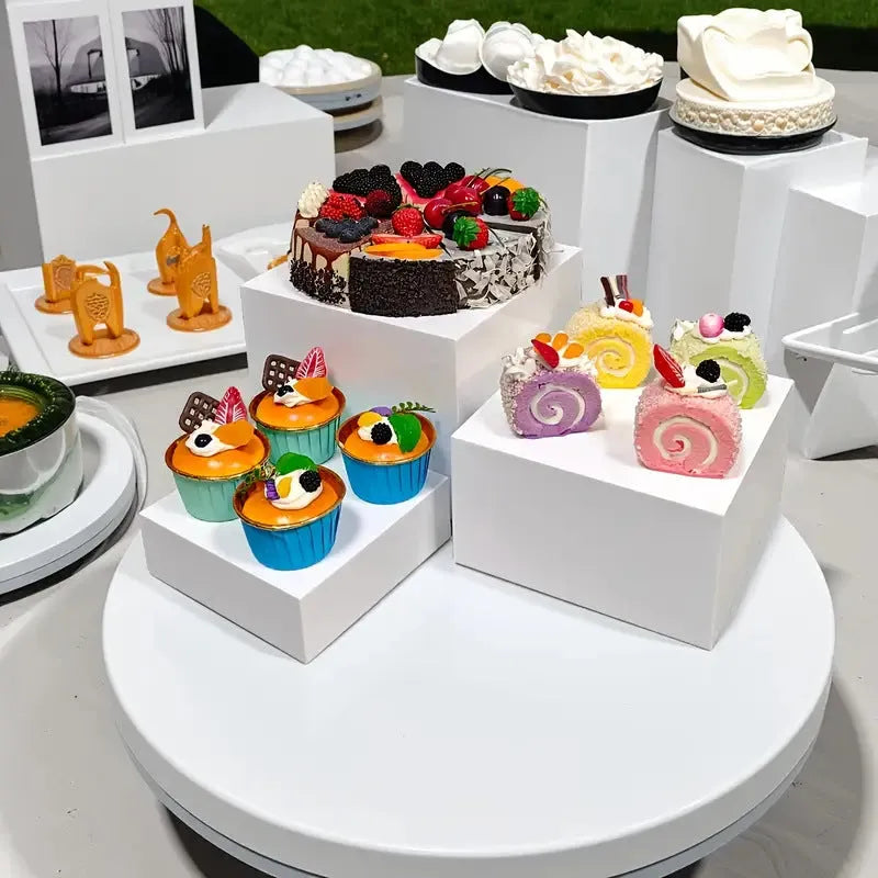 White plastic modular dessert display stand with six interlocking cubes for cake and pastry presentation