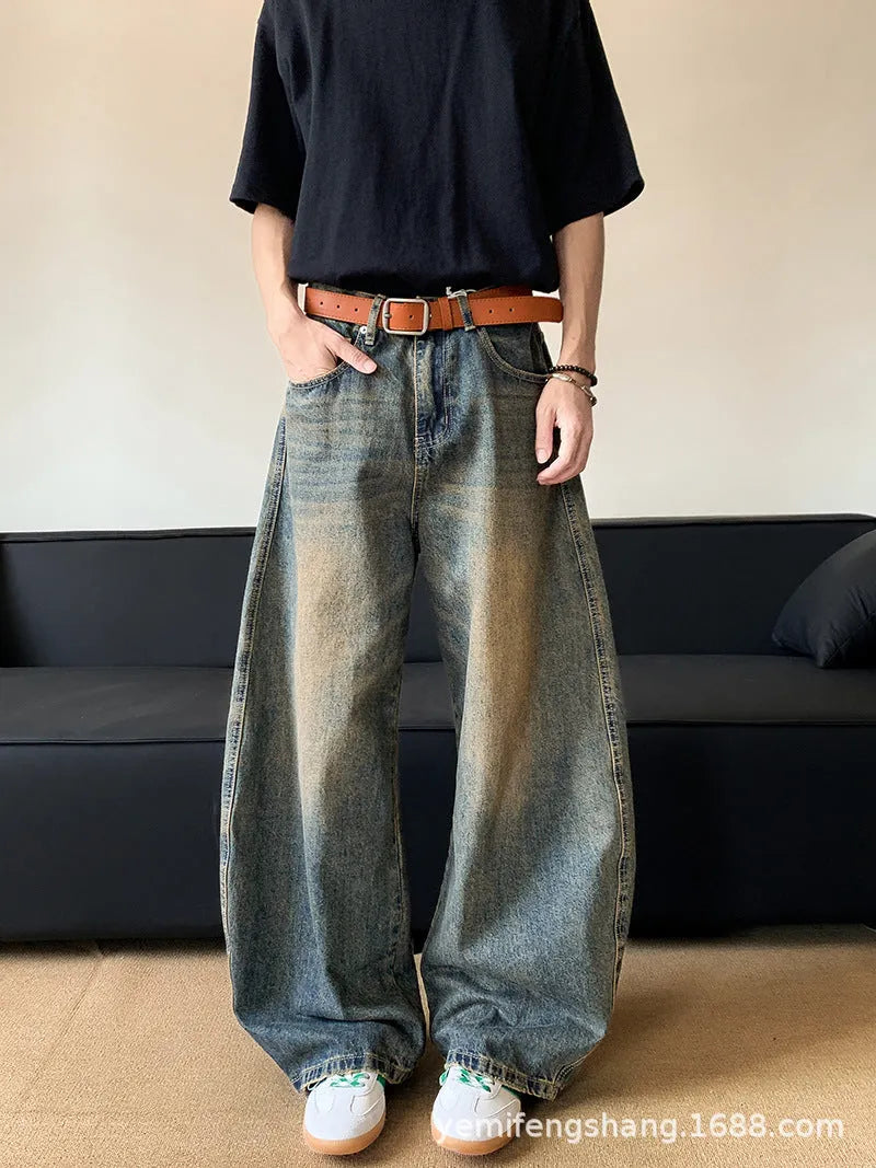 Men's retro blue distressed denim pants with a slim wide-leg fit and a zipper fly.