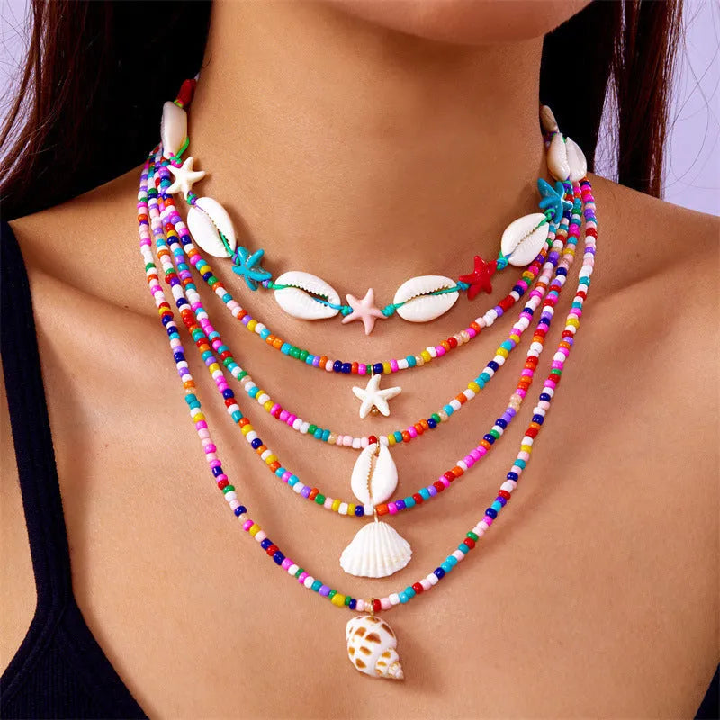 Five-piece women's necklace set with starfish, shell and conch bead pendants on adjustable chains