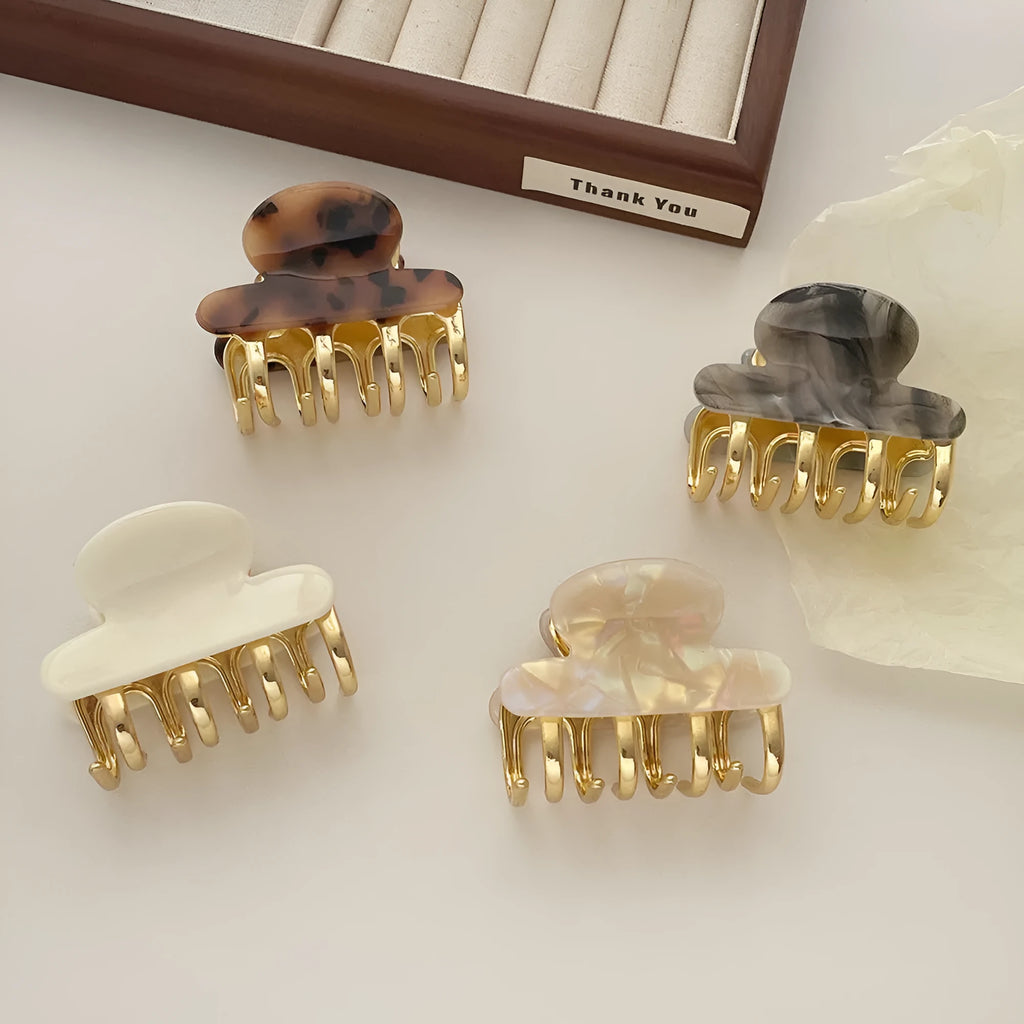 Medium metal grip acetate hair barrettes in four colours: fairy white, leopard print, creamy-white, and ink colour