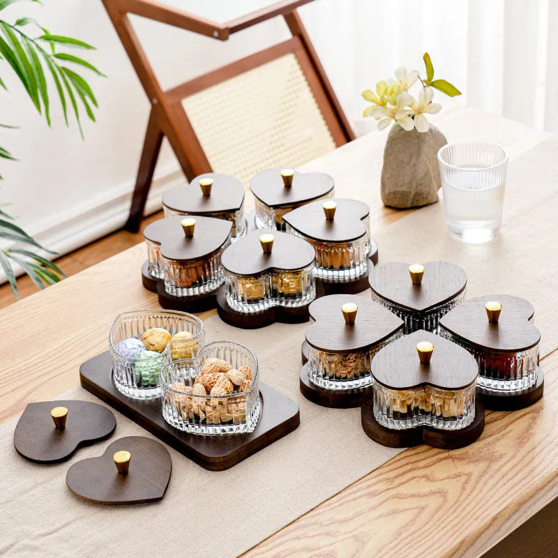 Glass fruit platter with transparent heart-shaped lids covering compartmentalised snack trays in retro design