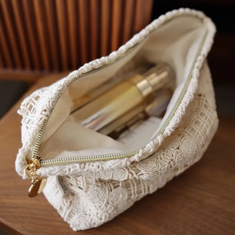 Handmade crocheted corduroy cosmetic bag with hollow flower cutouts and ethnic embroidery in a rope colour.