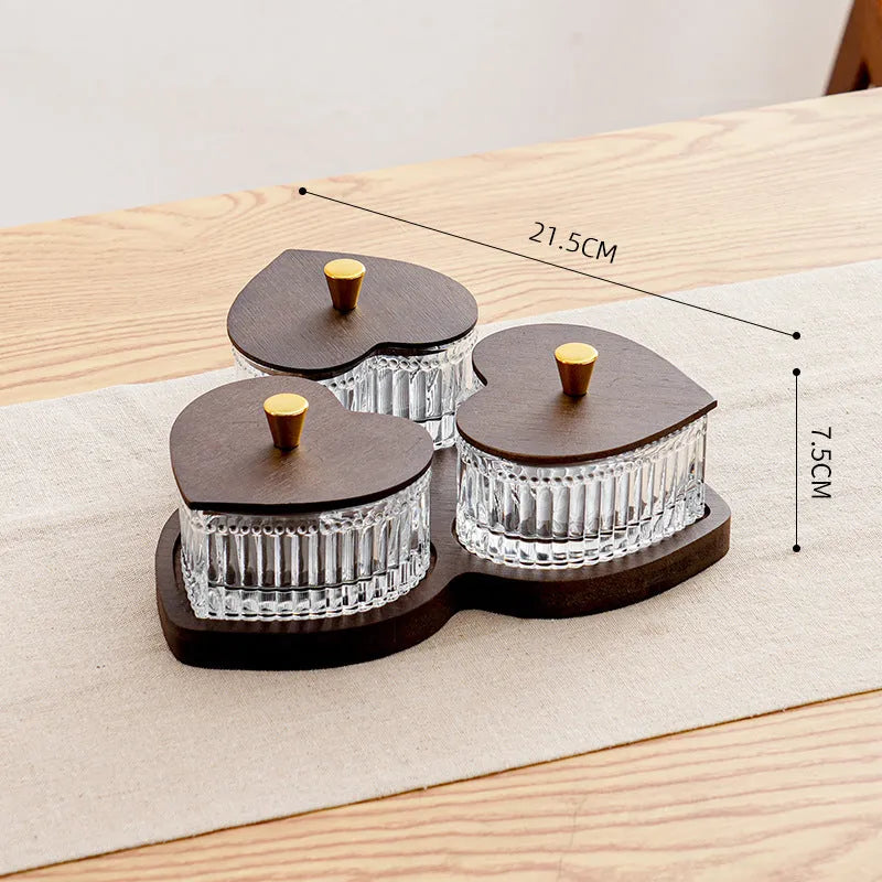 Glass fruit platter with transparent heart-shaped lids covering compartmentalised snack trays in retro design