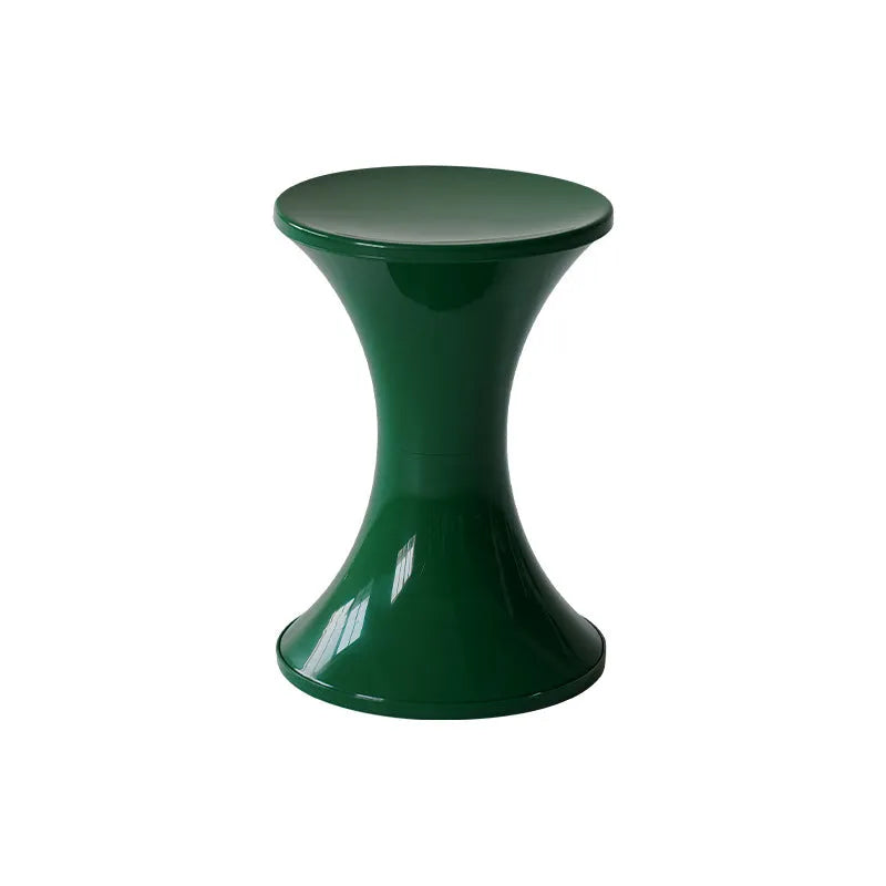 A plastic hourglass-shaped shoe changing stool in green colour on a wooden floor.