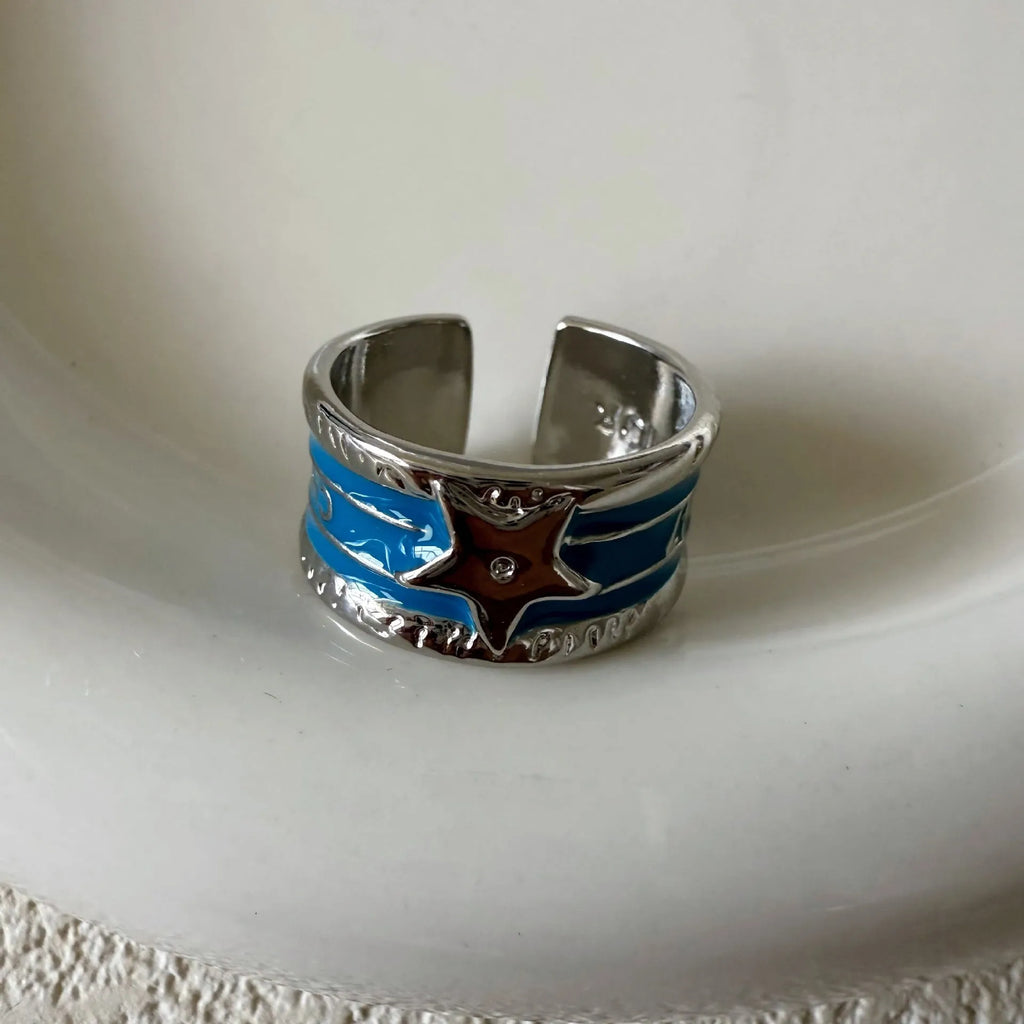 Adjustable geometric drop oil copper ring with a distressed finish in multiple colours.