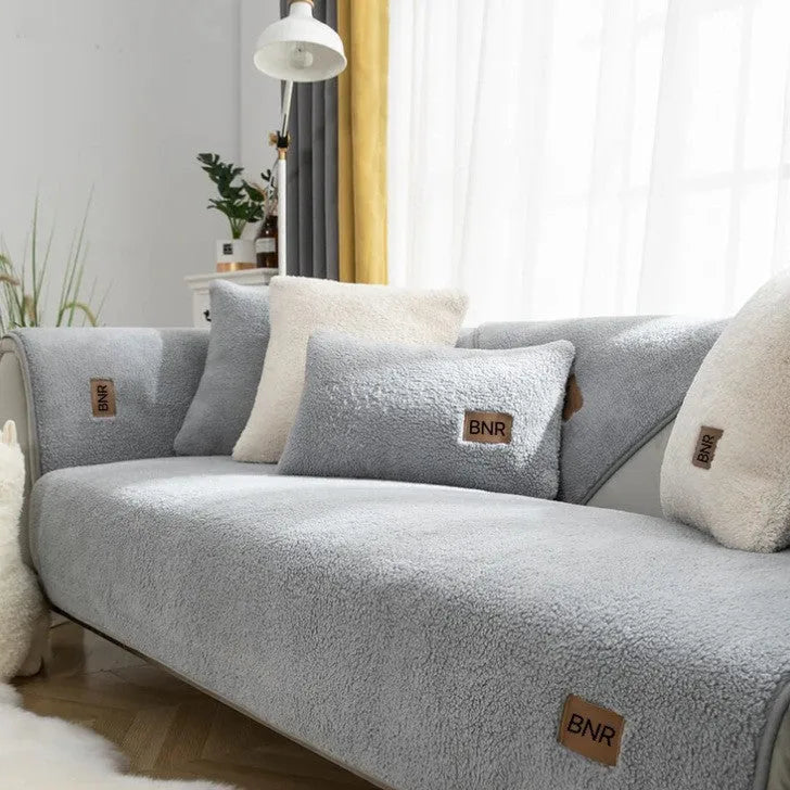 Lambswool sofa slipcover in solid blue colour on a grey sofa