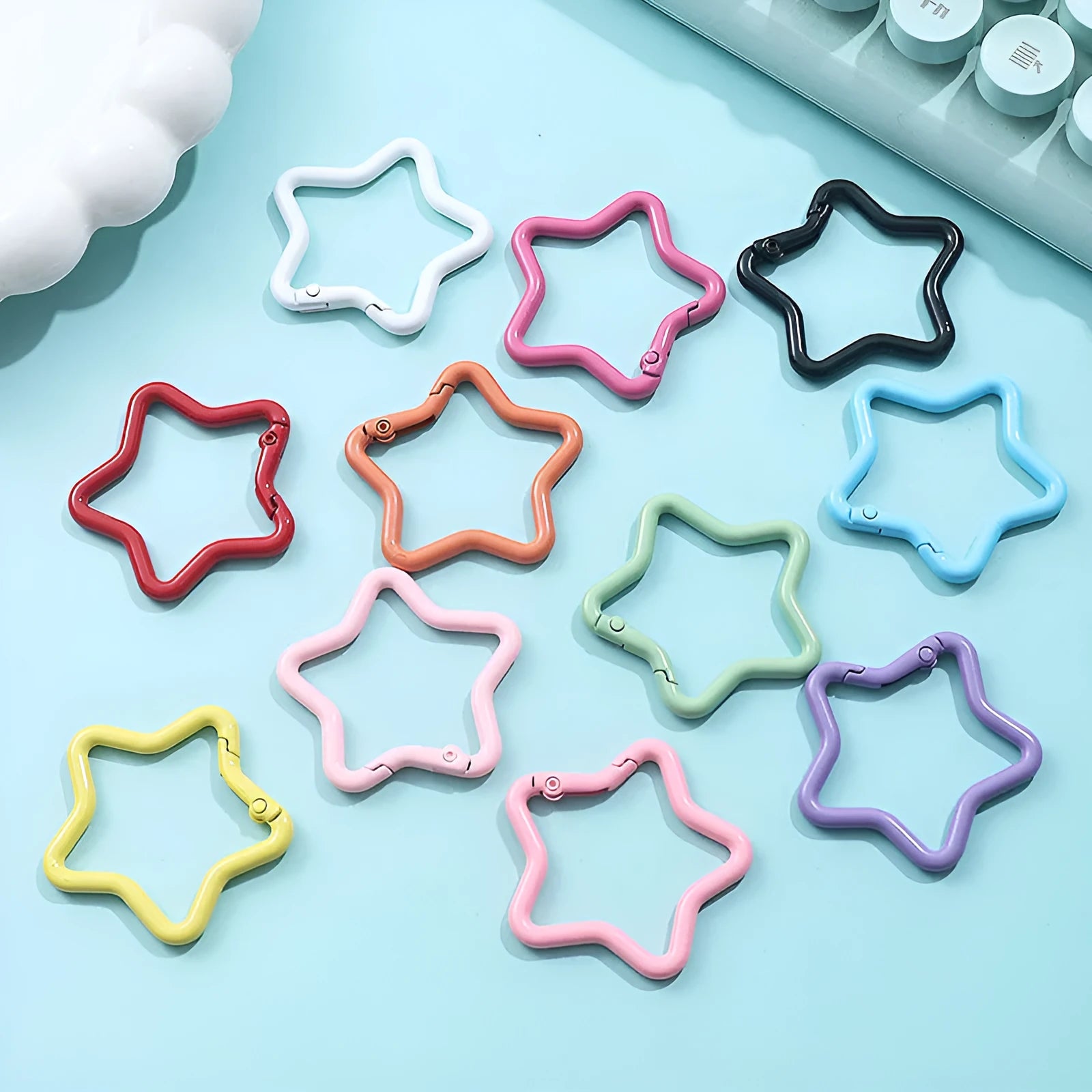 Zinc alloy five-pointed star keychain in light pink colour on a white background.