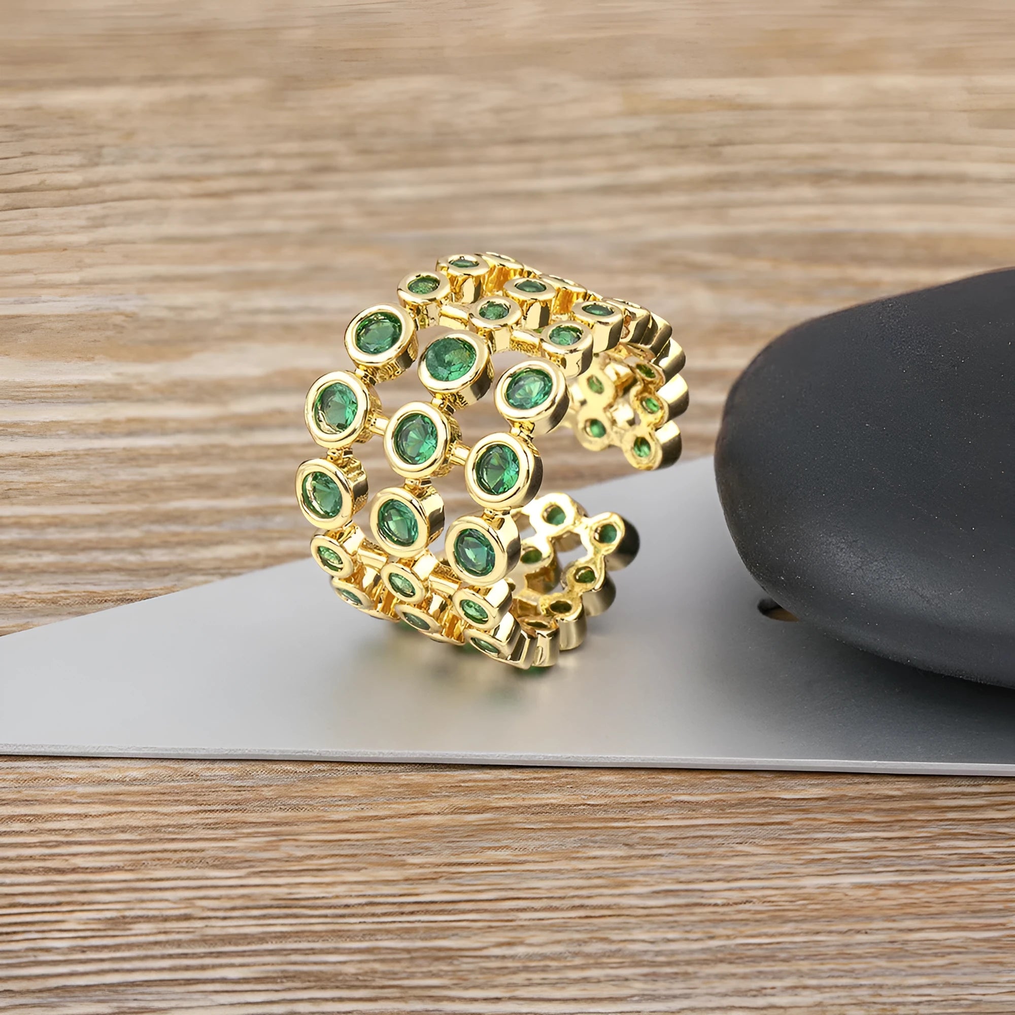 Gold plated copper ring with three green zircon stones in layered arrangement on wide band
