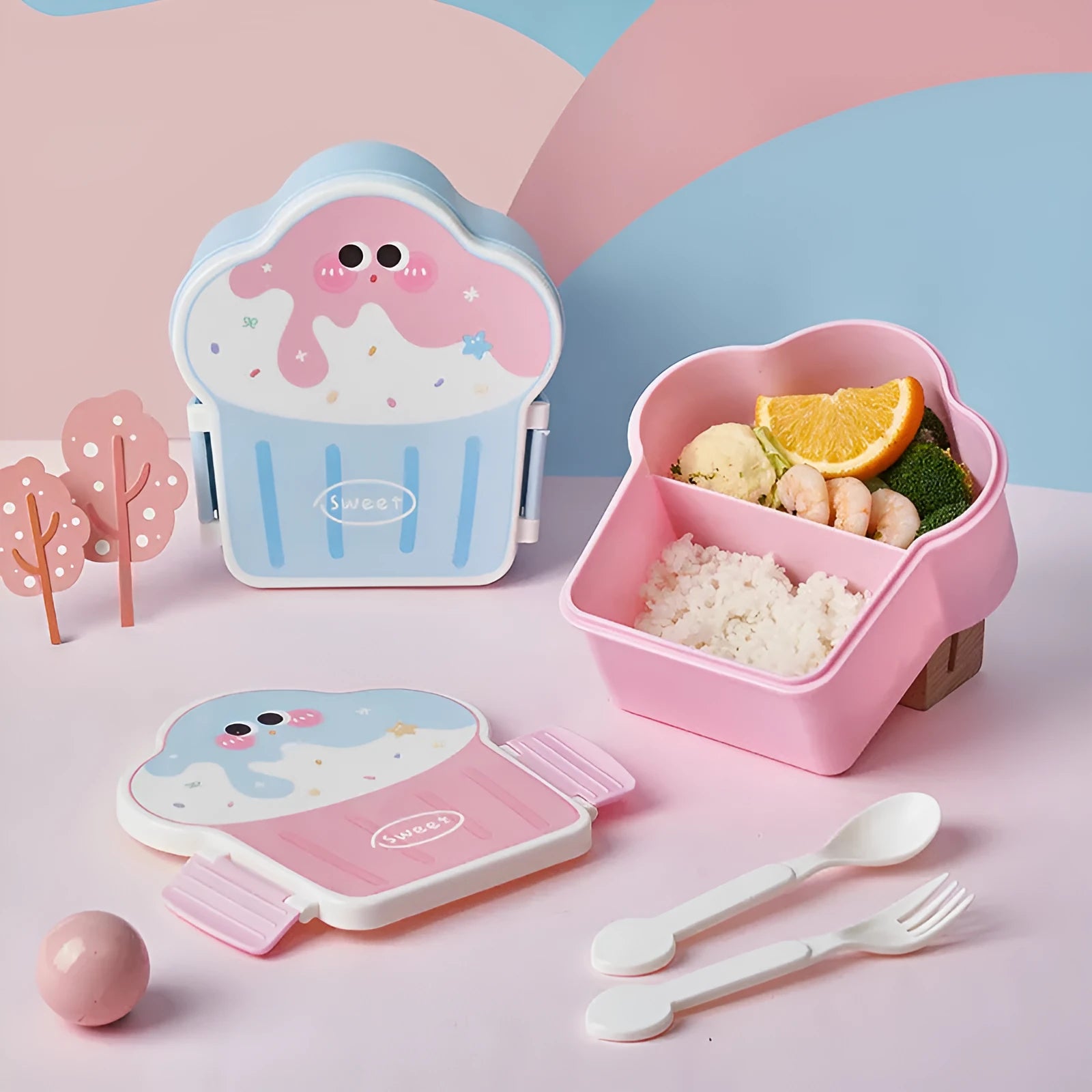 Pink and blue creative ice cream shaped plastic lunch box with spoon and fork set on a white background.