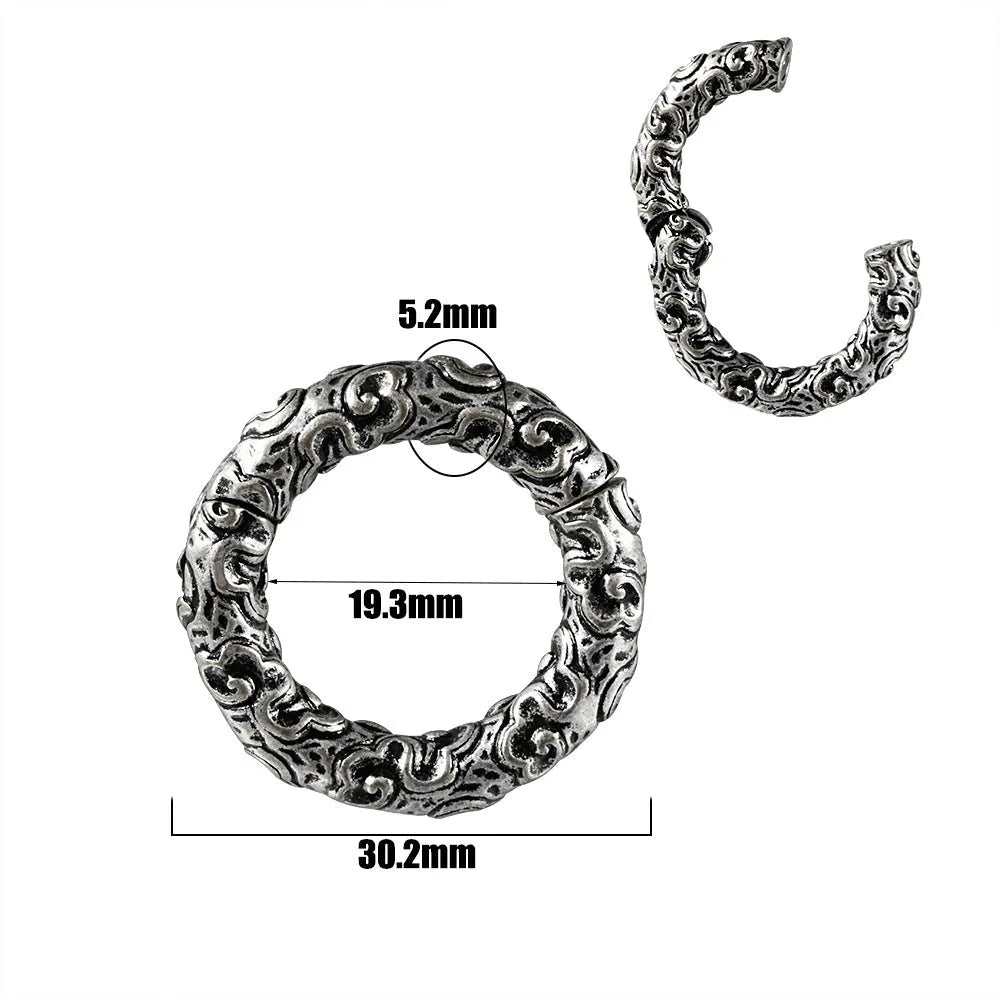 A pair of silver totem pattern stainless steel fashion earrings on a white background.