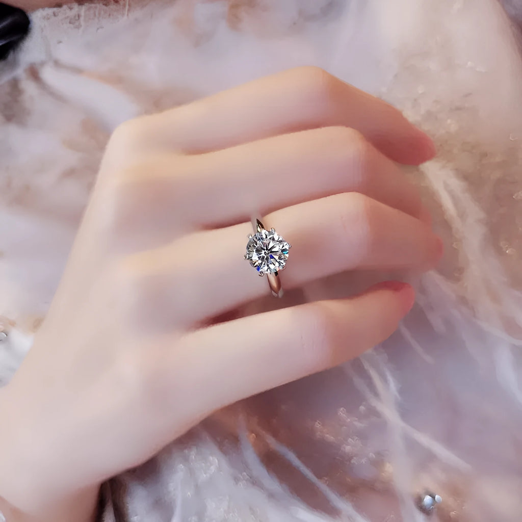 White gold plated geometric women's ring with a six-claw zircon setting, shown on a hand.