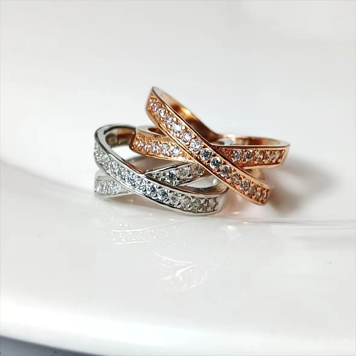 A silver or rose gold plated metal ring with a cross design and micro-inlaid zircon detail.