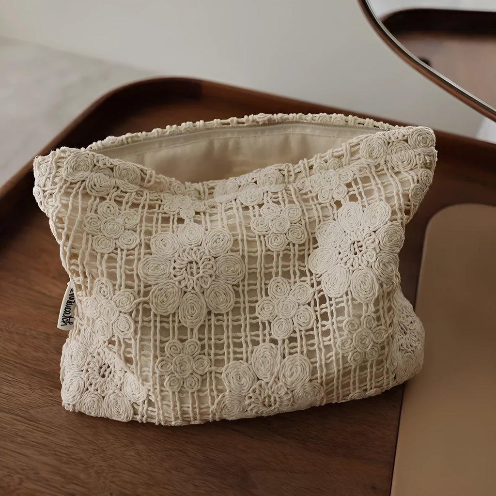 Handmade crocheted corduroy cosmetic bag with hollow flower cutouts and ethnic embroidery in a rope colour.