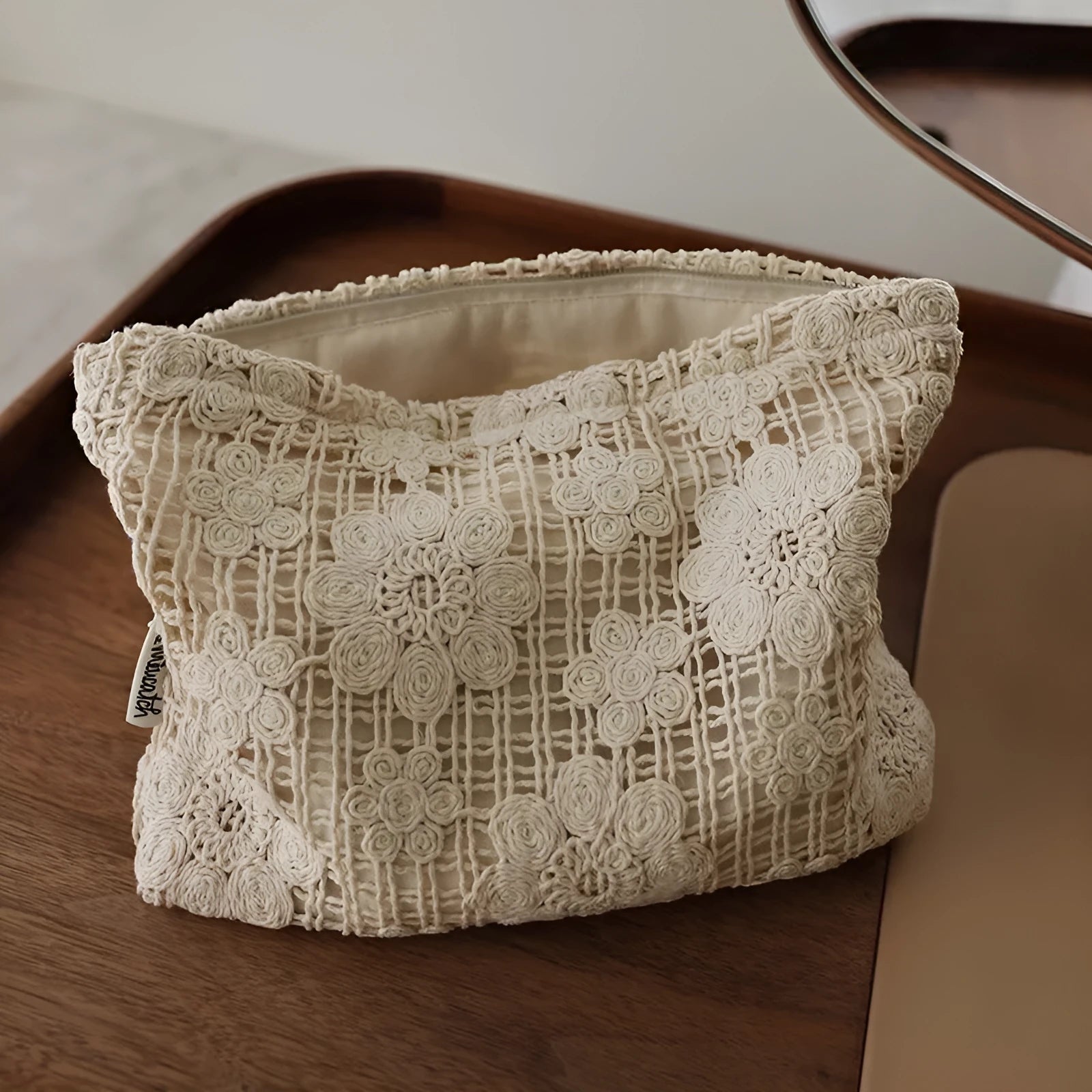 Handmade crocheted corduroy cosmetic bag with hollow flower cutouts and ethnic embroidery in a rope colour.