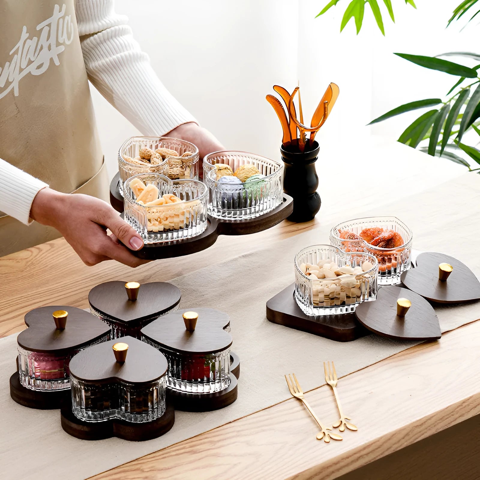 Glass fruit platter with transparent heart-shaped lids covering compartmentalised snack trays in retro design
