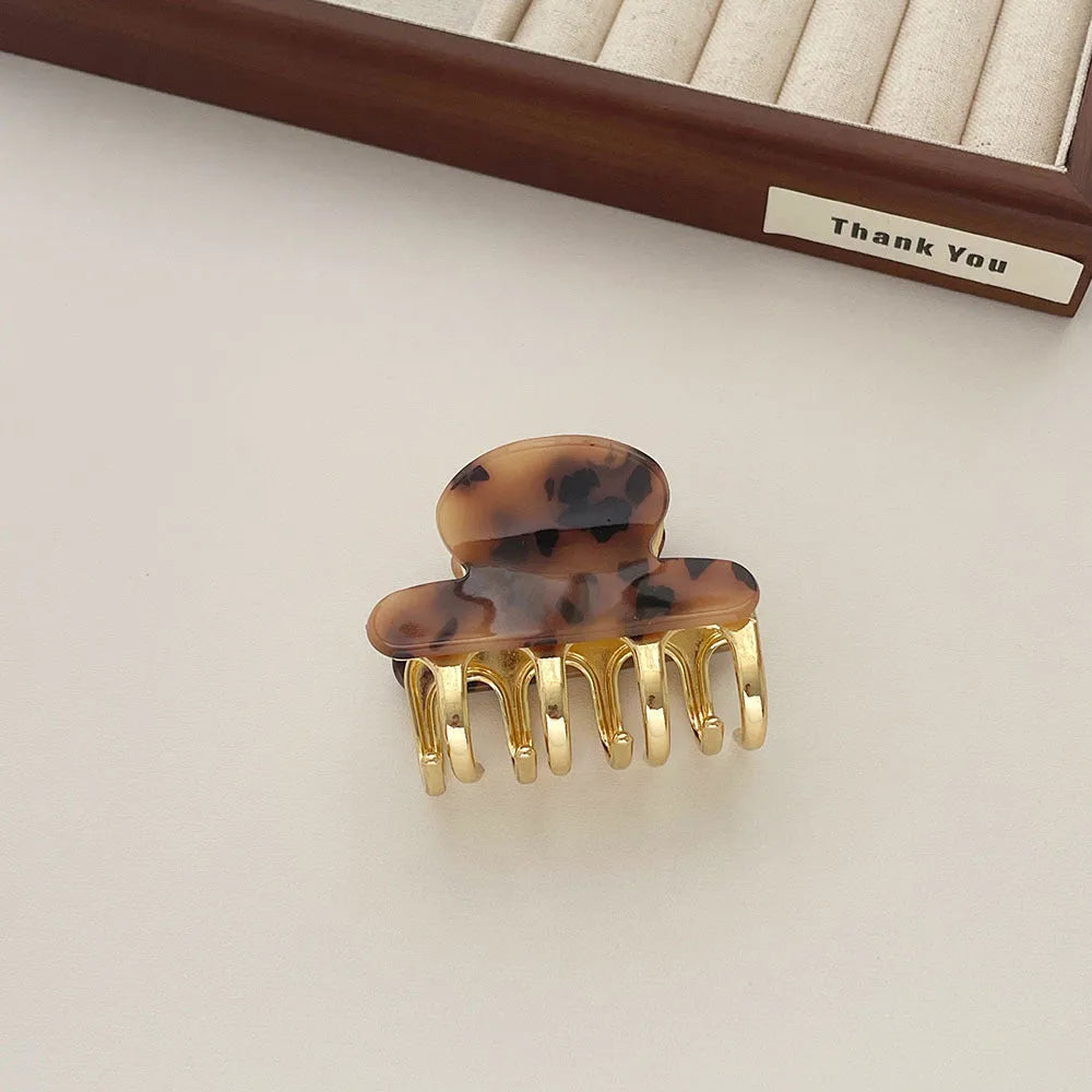 Medium metal grip acetate hair barrettes in four colours: fairy white, leopard print, creamy-white, and ink colour