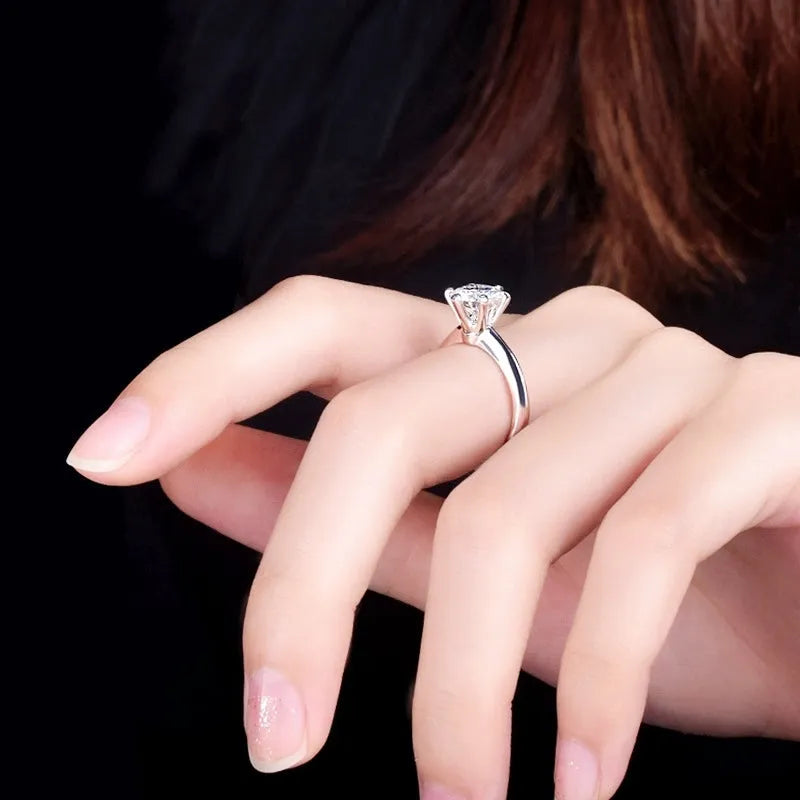 White gold plated geometric women's ring with a six-claw zircon setting, shown on a hand.