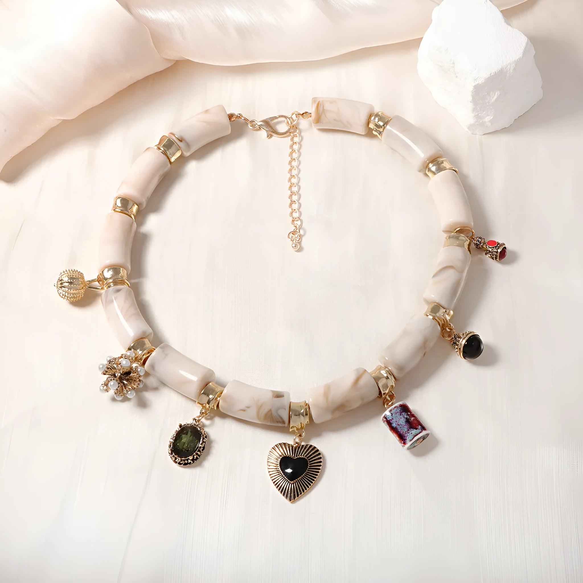 Gold-plated chain necklace with a white heart-shaped resin bamboo pendant.