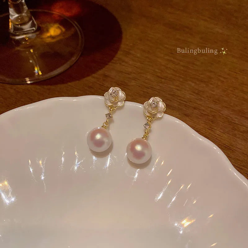Women's camellia flower stud earrings with pearl accent on alloy base