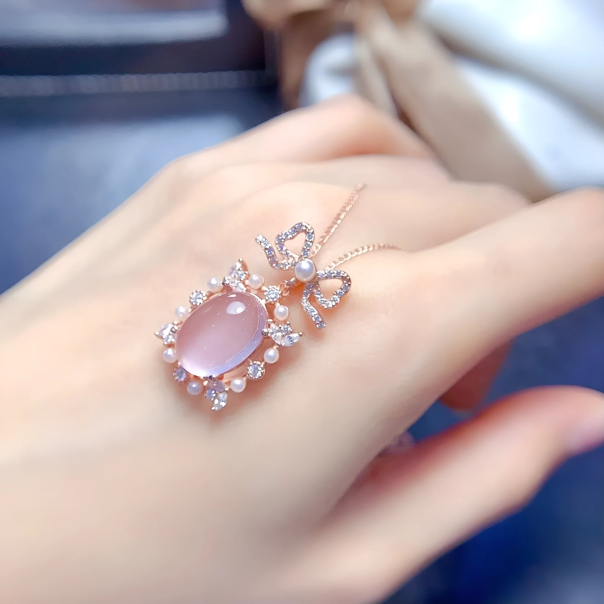 Geometric rose gold plated silver pendant with a pink rose quartz crystal on a necklace chain.