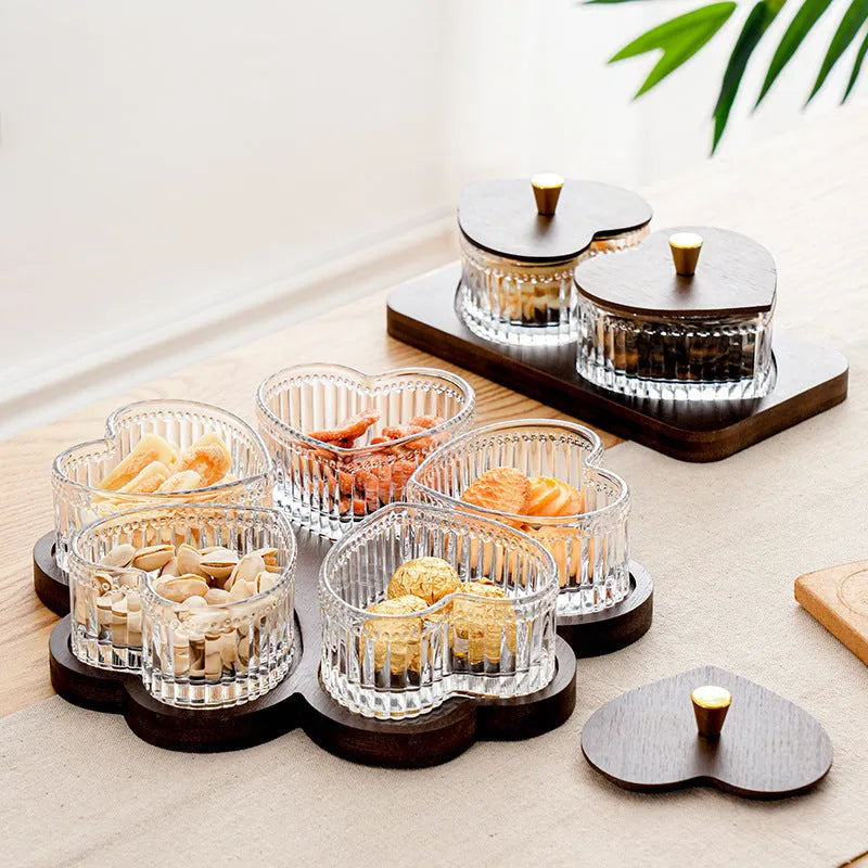 Glass fruit platter with transparent heart-shaped lids covering compartmentalised snack trays in retro design