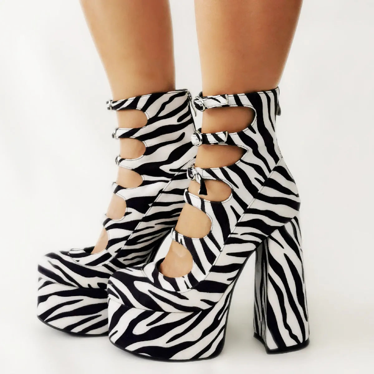Women's black patent leather platform high heels with a thick heel and buckle-fastened serpentine belt.