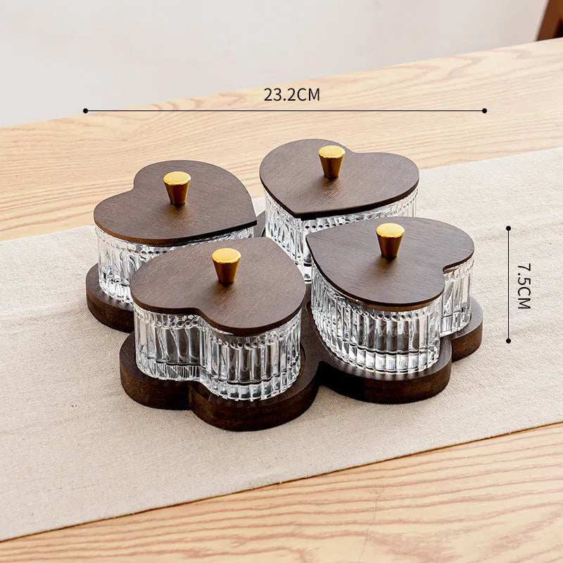 Glass fruit platter with transparent heart-shaped lids covering compartmentalised snack trays in retro design