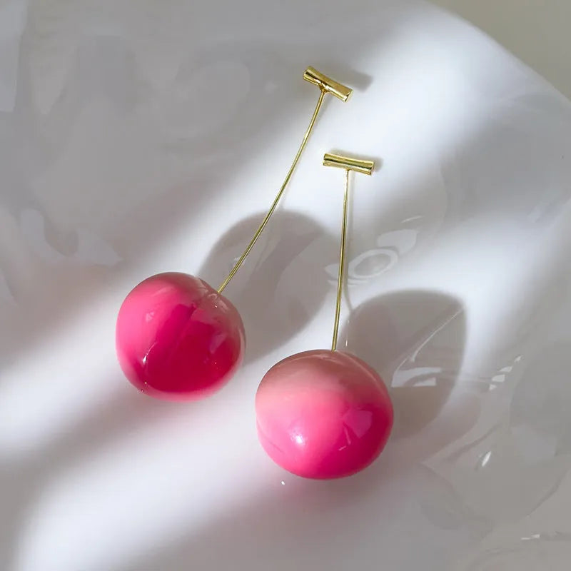 Pair of acrylic peach-shaped earrings on a white background, showing small and large size options.