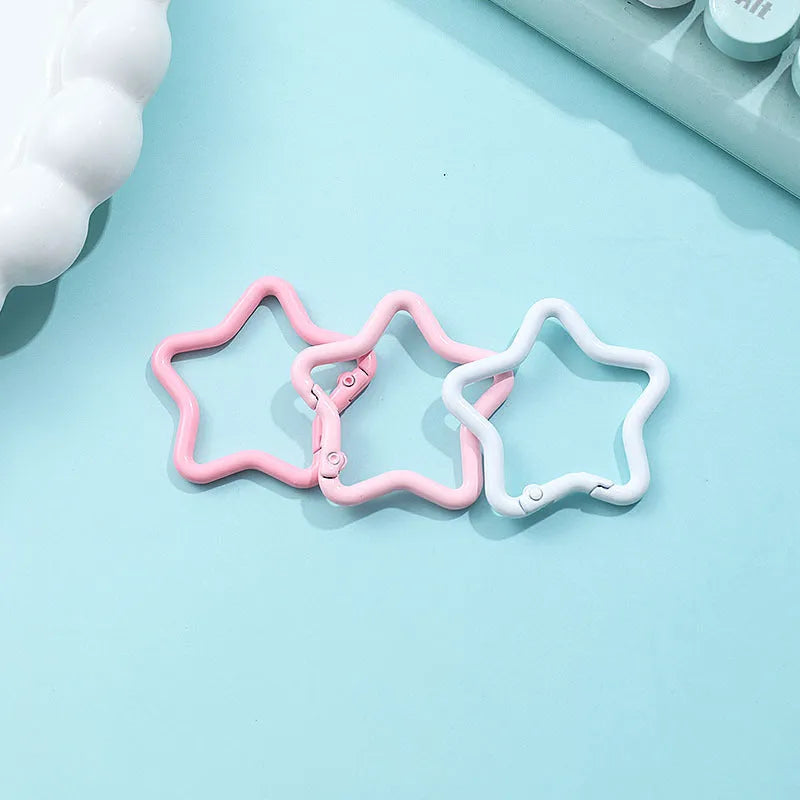 Zinc alloy five-pointed star keychain in light pink colour on a white background.
