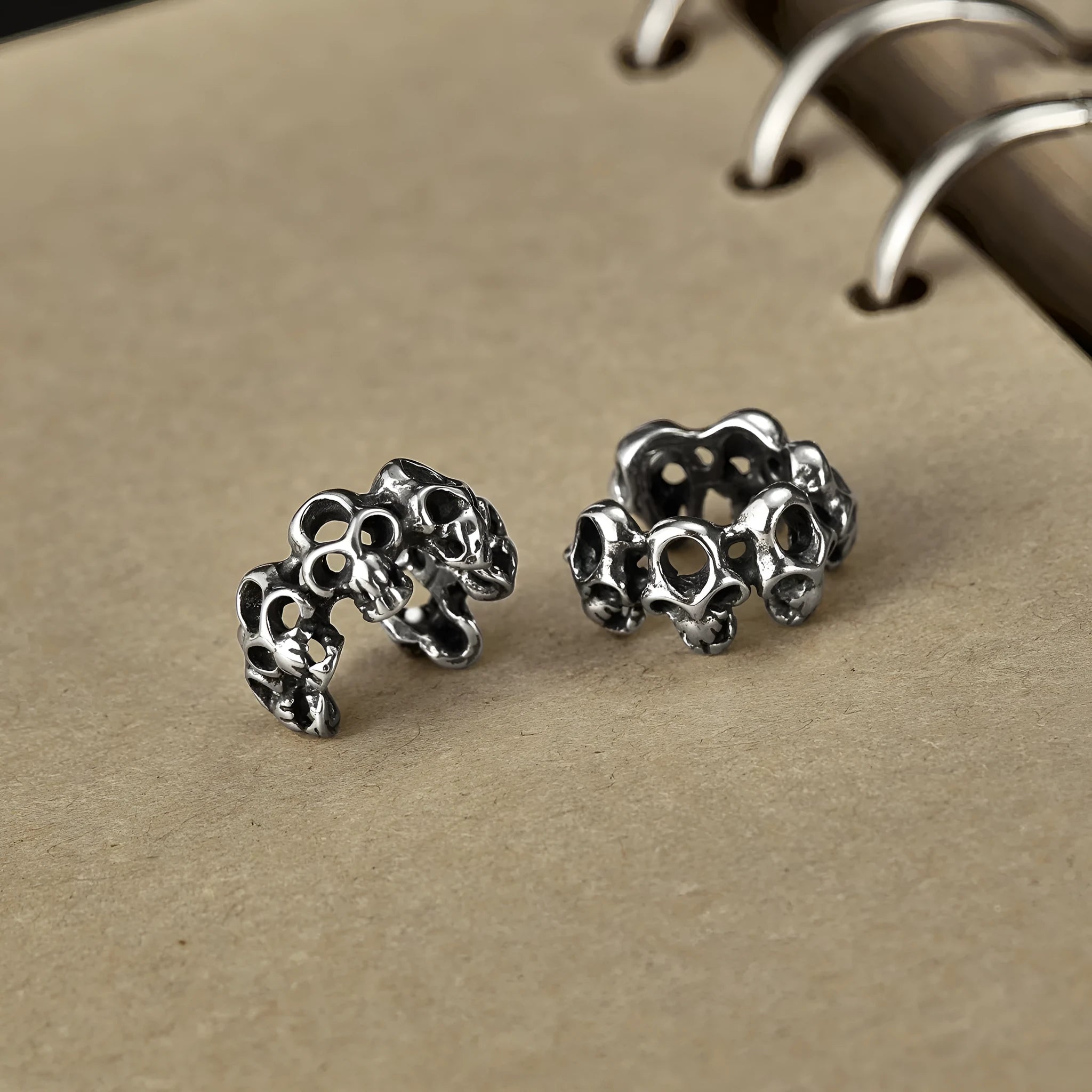 Stainless steel hollow skull ear clips with geometric design and metallic finish