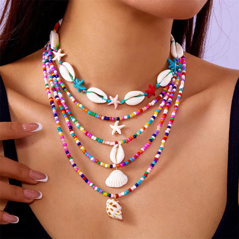 Five-piece women's necklace set with starfish, shell and conch bead pendants on adjustable chains