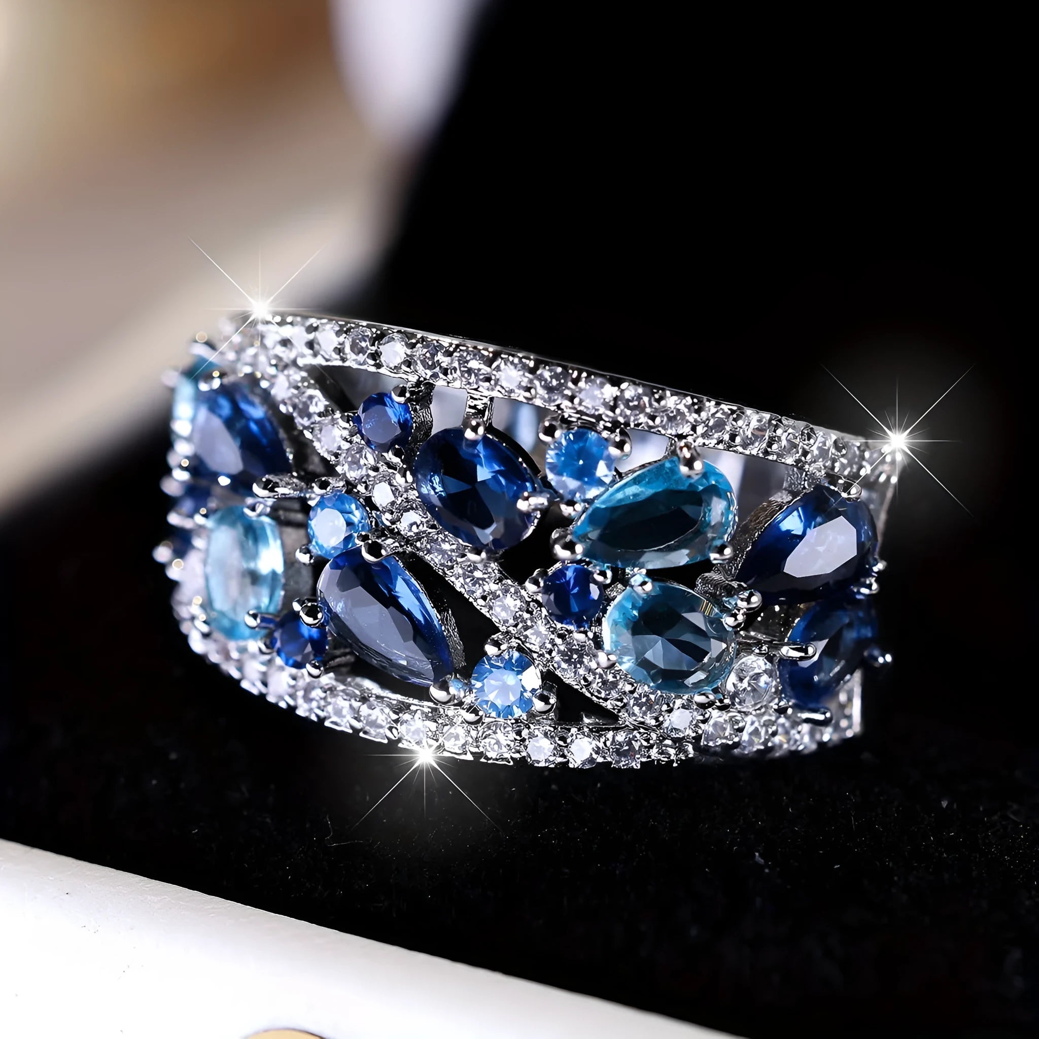 Women's hollow round fashion ring in gold or platinum with a choice of white or blue gemstone.