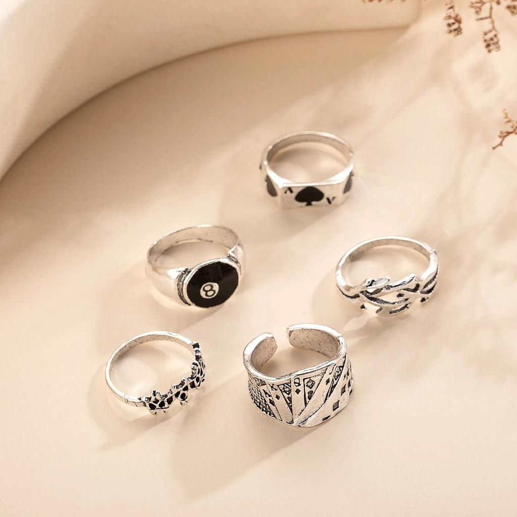Black alloy poker ring with a detailed retro spade design on a female model's hand.