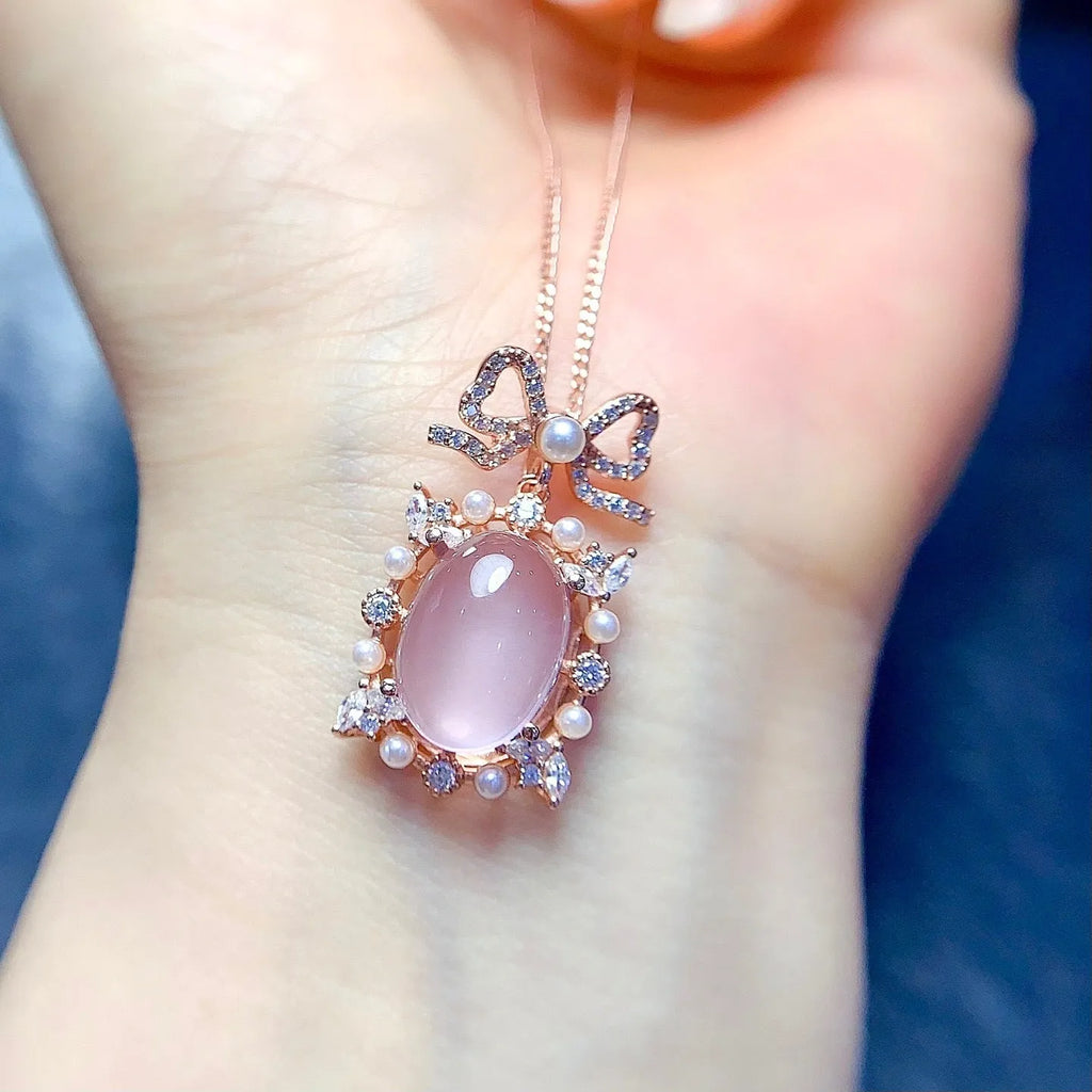 Geometric rose gold plated silver pendant with a pink rose quartz crystal on a necklace chain.