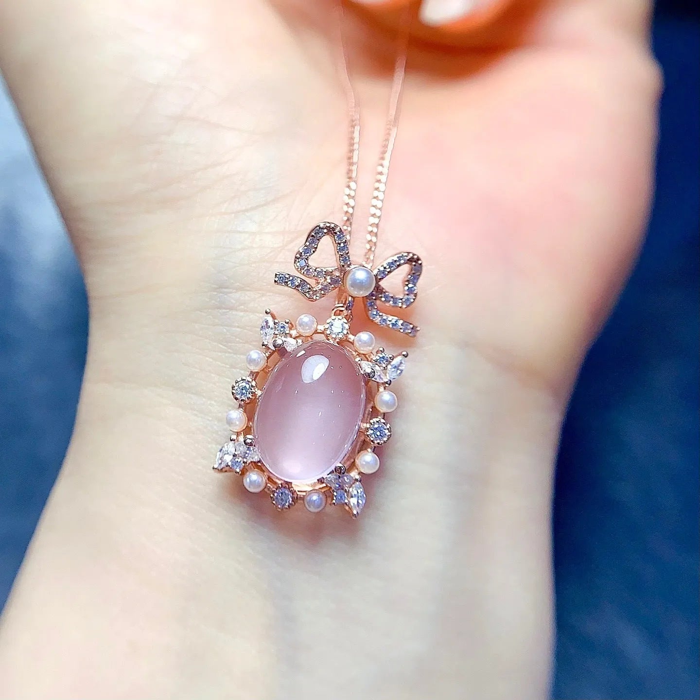 Geometric rose gold plated silver pendant with a pink rose quartz crystal on a necklace chain.